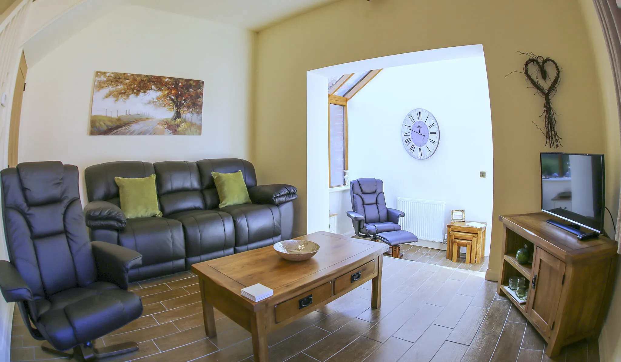 Chestnut Barn lounge with a three-seater leather reclining sofa and a TV