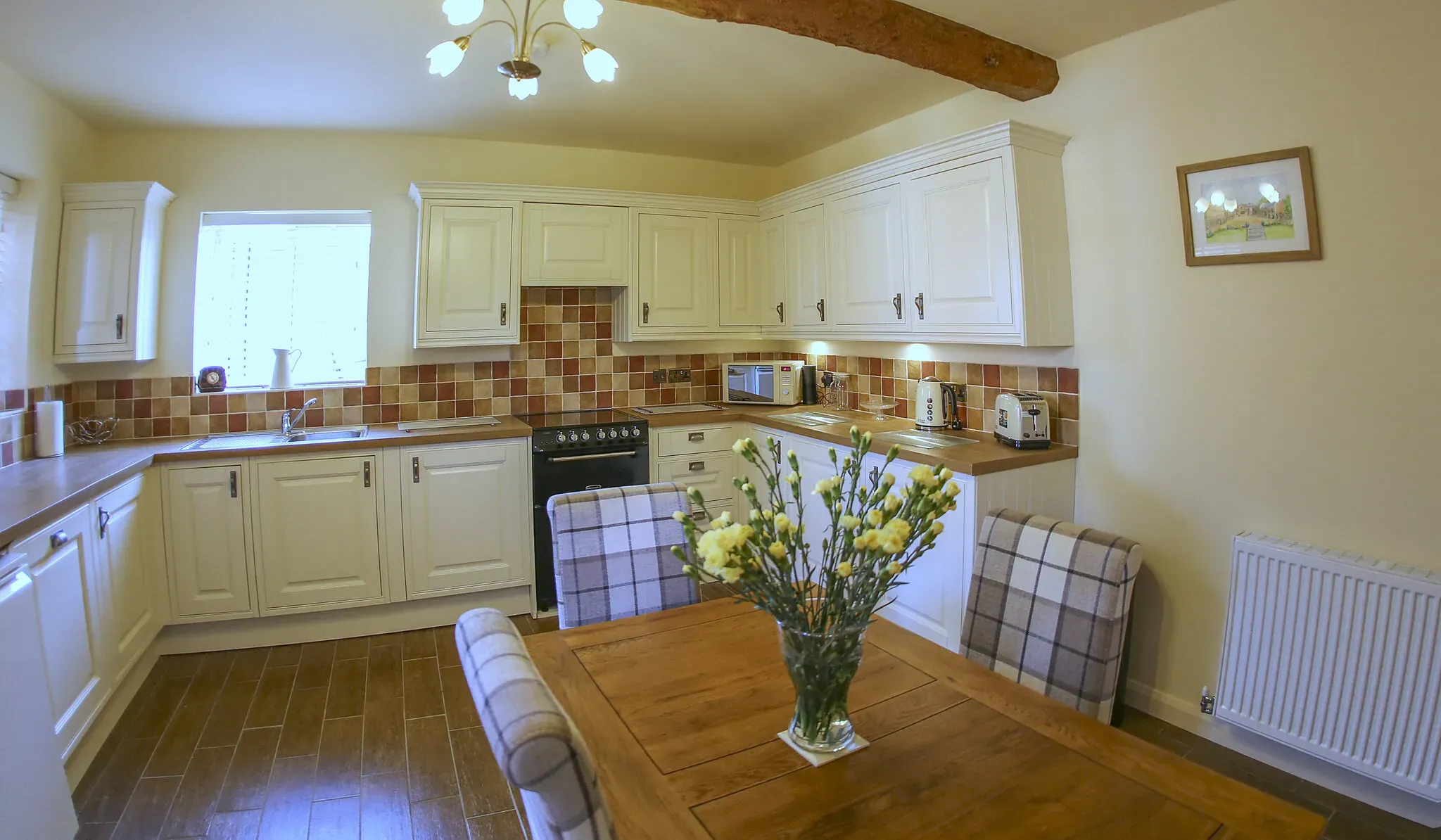 Chestnut Barn kitchen-diner with cream units, range cooker and an oak table for four